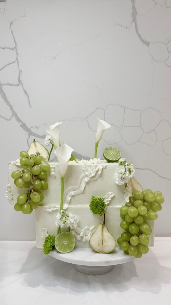 Square wedding cake with green grapes, pears, limes and calla lilies