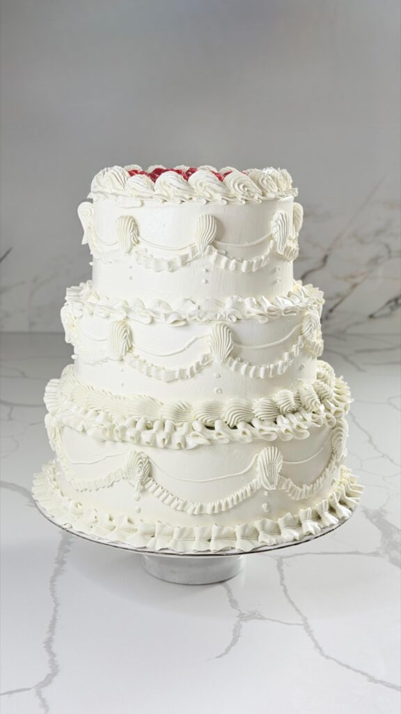 Three-tier vintage lambeth wedding cake in white buttercream